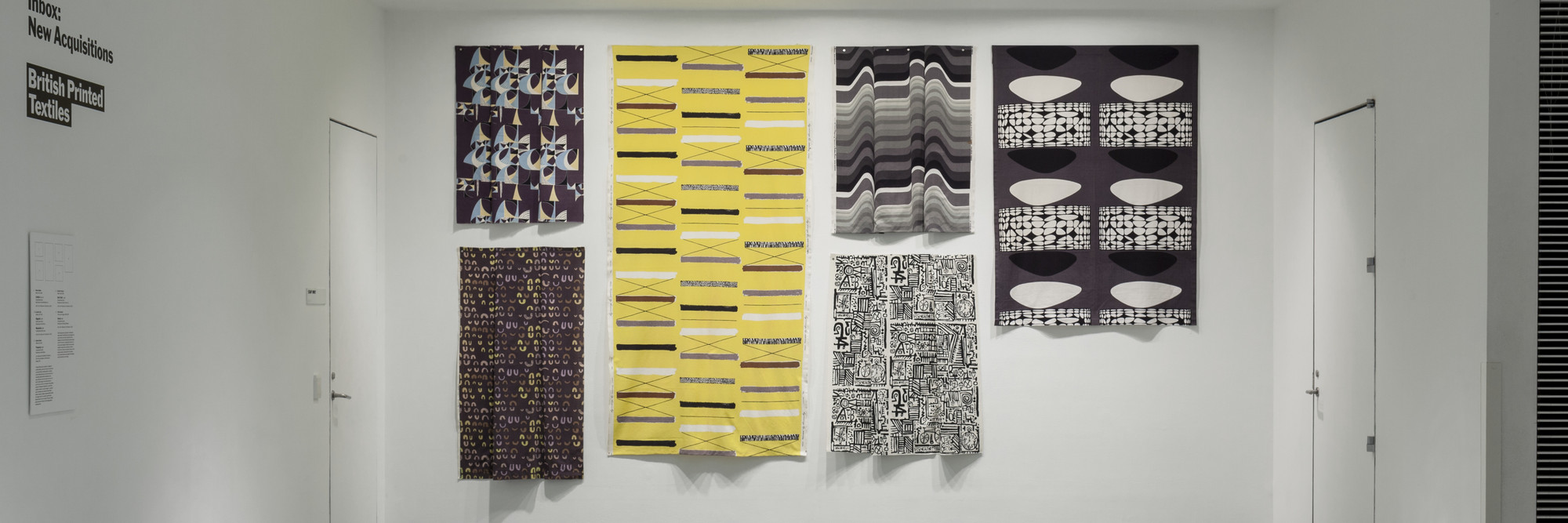 Installation view of Inbox: British Printed Textiles. From top to bottom, left to right: Marian Mahler (British, 1911–1983). Untitled. 1952–53. Screenprinted rayon, 40 1/2 × 45 1/2″ (102.9 × 115.6 cm). Manufacturer: David Whitehead Ltd. Gift of Jill A. Wiltse and H. Kirk Brown III, 2015. Lucienne Day (British, 1917–2010). Magnetic (Furnishing fabric). 1957. Roller-printed cotton, 54 × 49 1/2″ (137.2 × 125.7 cm). Manufacturer: Heal Fabrics. Lucienne Day. Mezzanine. 1958. Screenprinted cotton crepe, 95 1/2 × 48 1/4″ (242.6 × 122.6 cm). Gift of Jill A. Wiltse and H. Kirk Brown III, 2015. Barbara Brown (British, born 1932). Frequency (Furnishing fabric). 1969. Screenprinted cotton, 49 1/2 × 44 1/2″ (125.7 × 113 cm). Manufacturer: Heal Fabrics. Jill A. Wiltse and H. Kirk Brown III Collection, Gift of the Committee on Architecture &amp; Design, 2015. Eduardo Paolozzi (British, 1924–2005). Bark Cloth. c. 1954. Screenprinted cotton, 45 1/2 × 50 1/4″ (115.6 × 127.6 cm). Manufacturer: Hammer Prints Ltd. Gift of Jill A. Wiltse and H. Kirk Brown III, 2015. Victor Vasarely (French, born Hungary. 1908–1997). Kernos (Furnishing fabric). 1962. Screenprinted cotton, 70 × 47 3/4″ (177.8 × 121.3 cm). Manufacturer: Edinburgh Weavers. Gift of Jill A. Wiltse and H. Kirk Brown III, 2015. Photo: John Wronn
