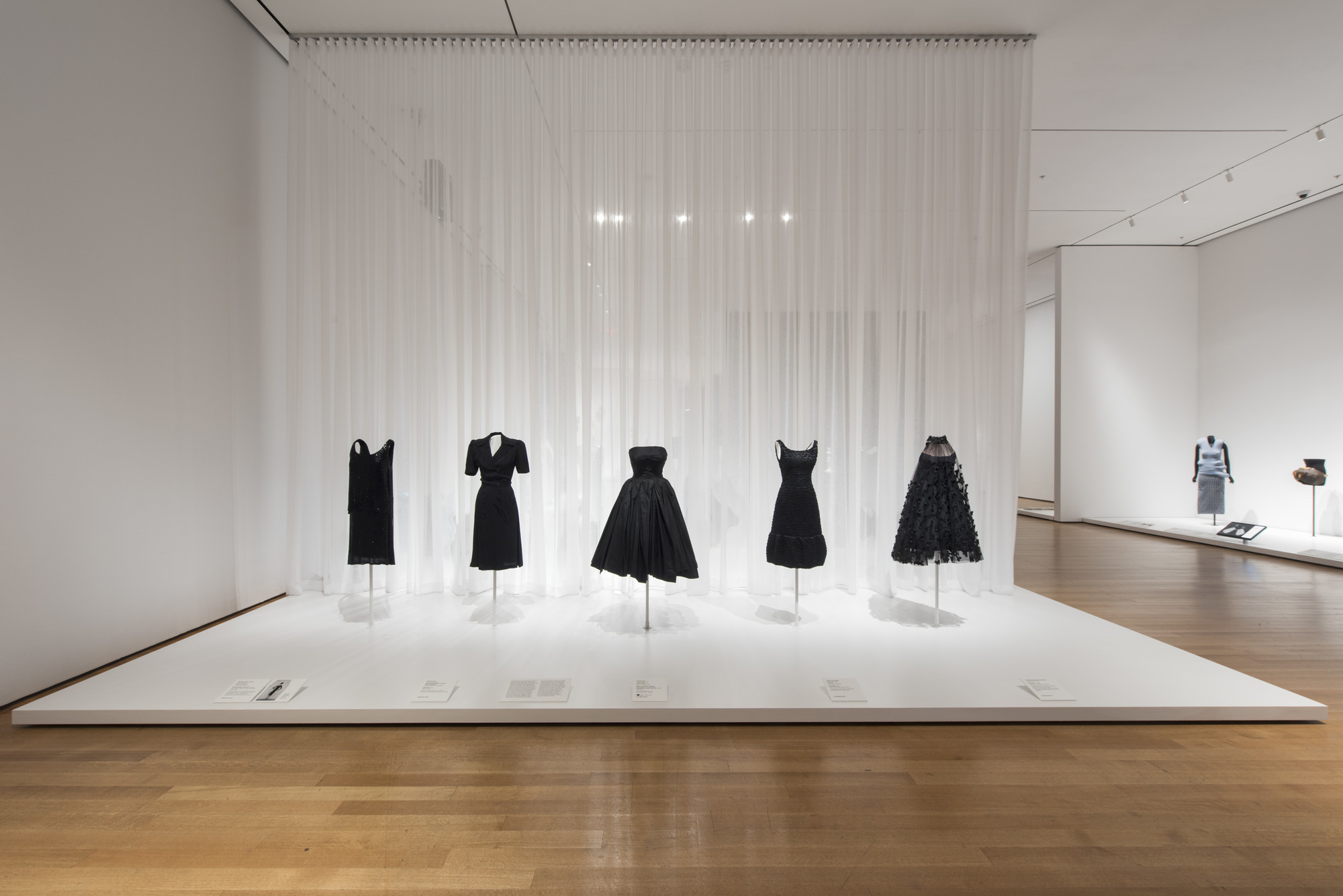Gabrielle “Coco” Chanel (French, 1883–1971). House of Chanel (France, founded 1913). Evening dress. 1925–27. Silk chiffon, crepe-back satin, and glass bugle beads. Fashion Institute of Design & Merchandising, Los Angeles. Helen Larson Historic Fashion Collection. Purchase: FIDM Museum Fashion Council and other generous donors. Charles Creed (British, 1909–1966). Incorporated Society of London Fashion Designers (United Kingdom, founded 1942) Dress. 1942. Rayon crepe. Victoria and Albert Museum, London. Given by the President of the Board of Trade.Christian Dior (French, 1905–1957). House of Dior (France, founded 1947). Two-piece dress
(bodice and skirt). c. 1950. Silk taffeta. Indianapolis Museum of Art. Gift of Eleanore R. Carruth. Hubert de Givenchy (French, born 1927). Givenchy (France, founded 1952). Dress. 1968. Satin, jet beading, and equin trim. The Museum at the Fashion Institute of Technology. Gift of Jane Holzer. Arnold Scaasi (born Arnold Isaacs) (Canadian, 1931–2015). Dress. c. 1966. Tulle, black net shawl, and ribbon. Robert and Penny Fox Historic Costume Collection at Drexel University. Gift of the Schneidman family in memory of Margaret (Peggy) Wright Schneidman Tilghman. Image taken during installation of _Items: Is Fashion Modern?_ 

