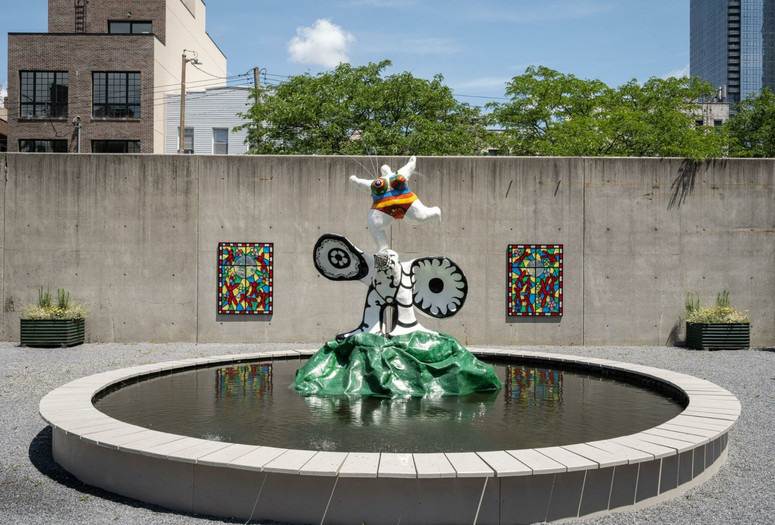 View of the PS1 Courtyard. Shown: Niki de Saint Phalle. La femme et L'oiseau fontaine. 1967. Painted polyester resin. Courtesy Galerie Mitterrand, Paris; Galerie GP &amp; N Vallois, Paris; and Salon 94, New York; Raúl de Nieves. The Stories of the Past Rejoice through Children's Skies. 2021. Courtesy the artist and Company Gallery, New York. Photo: Kris Graves