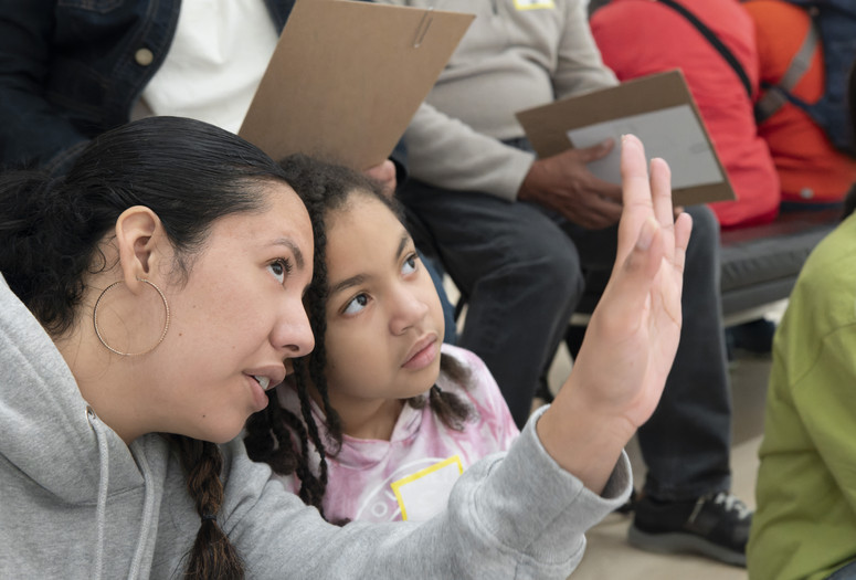 Photo: Martin Seck Image description: A family looks closely at art during a Family Gallery Talk.