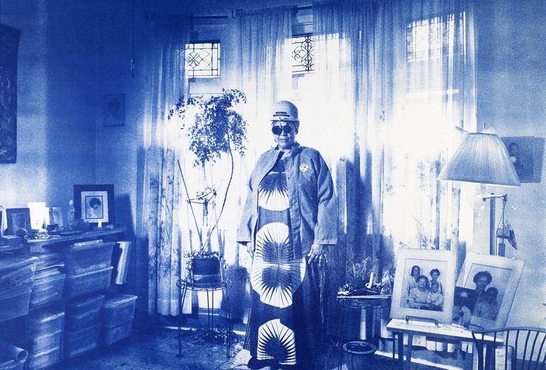 LaToya Ruby Frazier. Sandra Gould Ford Wearing Her Work Jacket and Hard Hat in Her Meditation Room in Homewood, PA, from On the Making of Steel Genesis: Sandra Gould Ford. 2017. © 2023 LaToya Ruby Frazier. Courtesy of the artist and Gladstone gallery