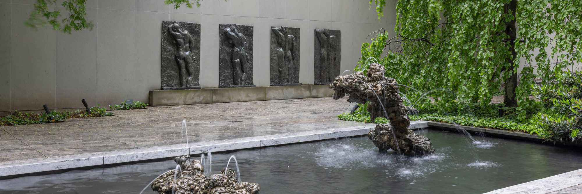 The Abby Aldrich Rockefeller Sculpture Garden, May 2024. Photo: Jonathan Dorado. Shown: Lynda Benglis. Double Fountain, Mother and Child. 2007. Bronze, in two parts. The Museum of Modern Art, New York. Gift of the artist and the Fuhrman Family Foundation; Henri Matisse. The Back (I). Spring 1908–late 1909; The Back (II). 1911 (?)–early March or April 1913; The Back (III). May 13, 1913–early fall 1916; The Back (IV). c. 1931. Bronze. The Museum of Modern Art, New York. Mrs. Simon Guggenheim Fund. © 2024 Succession H. Matisse/Artists Rights Society (ARS), New York