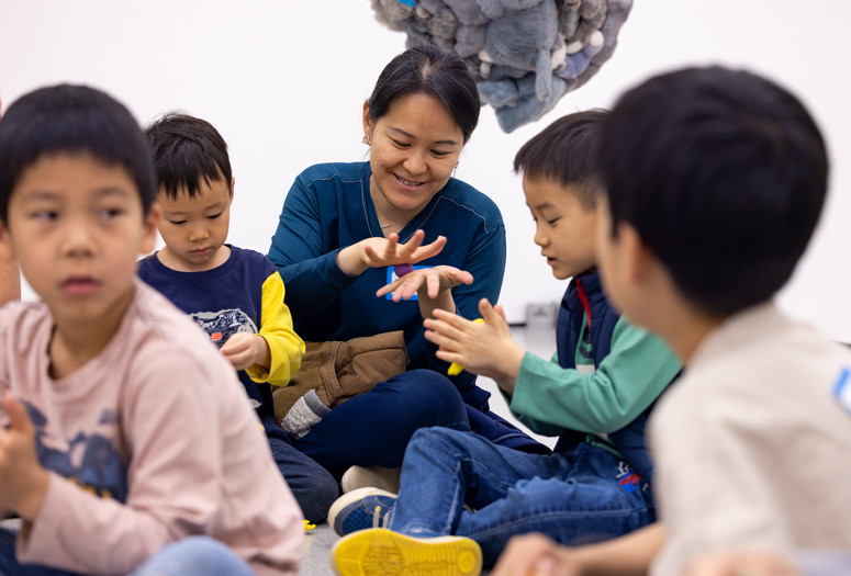 Photo: On White Wall Inc.Image description: Children and a caregiver play with model magic on the gallery floor