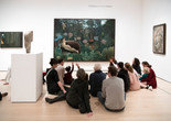 Photo: Martin SeckImage description: An educator leads a group of families in a discussion about an artwork.