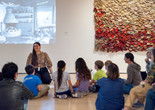 Photo: On White Wall Inc.Image description: An educator leads a discussion about an artwork for seated families.