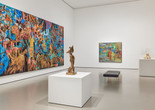 Installation view of Gallery 215: Jungle Jungle, The Museum of Modern Art, New York, May 2, 2025–ongoing. Photo: Martin Parsekian. Image description: a photograph of a gallery installed with colorful large-scale paintings on the wall and bronze sculptures on white pedestals, with a black gallery bench in the center