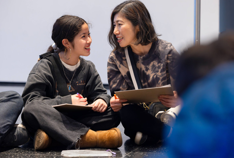 A mother and child look at each other and smile while doing an activity during a Family Gallery Talk. Photo: On White Wall, Inc.