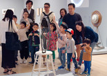 An educator leads a discussion with families in front of a sculpture made from a bicycle wheel. Shown: Marcel Duchamp. Bicycle Wheel. New York, 1951 (third version, after lost original of 1913). Metal wheel mounted on painted wood stool. The Museum of Modern Art, New York. The Sidney and Harriet Janis Collection. © 2026 Artists Rights Society (ARS), New York/ADAGP, Paris/Estate of Marcel Duchamp. Photo: On White Wall, Inc.