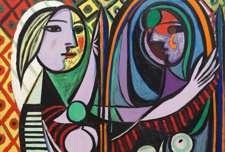 Pablo Picasso. Girl Before a Mirror. 1932. Oil on canvas. 64 x 51 1/4" (162.3 x 130.2 cm). Gift of Mrs. Simon Guggenheim. © 2026 Estate of Pablo Picasso / Artists Rights Society (ARS), New York. A colorful Cubist painting of a girl looking into a mirror. The composition is defined by bold black outlines, rich primary colors, and intricate diamond-patterned backgrounds that merge the figure with her environment.