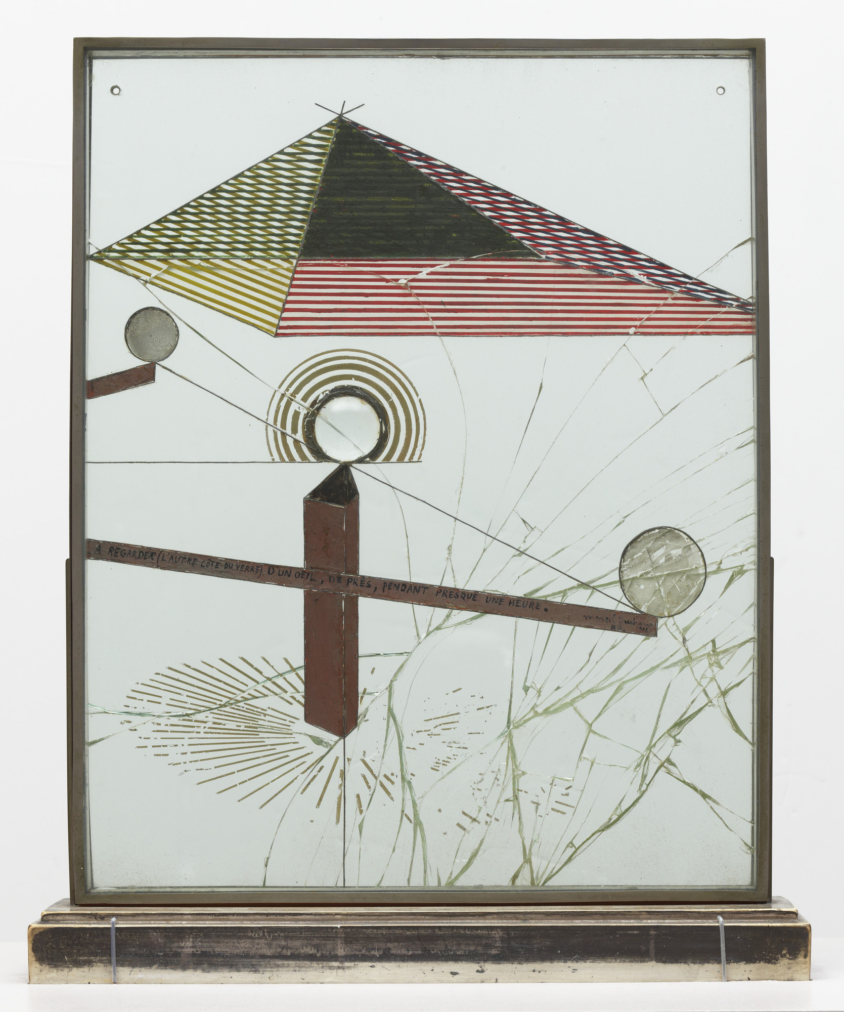 Marcel Duchamp. *To Be Looked at (from the Other Side of the Glass) with One Eye, Close to, for Almost an Hour*. 1918. Oil, silver leaf, lead wire, and magnifying lens on glass (cracked), mounted between panes of glass in a standing metal frame, 20 1/8 x 16 1/4 x 1 1/2" (51 x 41.2 x 3.7 cm), on painted wood base, 1 7/8 x 17 7/8 x 4 1/2" (4.8 x 45.3 x 11.4 cm), Overall 22" (55.8 cm) high. The Museum of Modern Art, New York. Katherine S. Dreier Bequest. © 2026 Artists Rights Society (ARS), New York / ADAGP, Paris / Estate of Marcel Duchamp