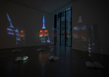 Lutz Bacher. Empire. 2014. High-definition video (color, sound, 10:43 min), two projectors, Plexiglas, sandbags, and metal stands. The Museum of Modern Art, New York. Acquired through the generosity of Lonti Ebers. © Lutz Bacher. Courtesy of the Estate of Lutz Bacher and Galerie Buchholz Image description: A room houses an artwork featuring projections of the Empire State Building at night on plexiglass.