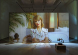 Christopher Kulendran Thomas. Being Human. 2019. High-definition video (color, sound; 24 min.) projected on glass, with three paintings and three sculptures: Untitled II, Untitled V, and Untitled VI (2018) by Upali Ananda, and Untitled II and Untitled V (2018) by Kingsley Gunatillake (all purchased by the artist from Saskia Fernando Gallery, Colombo); and Untitled X after Kingsley Gunatillake (2019) by Christopher Kulendran Thomas. In collaboration with Annika Kuhlmann. The Museum of Modern Art, New York. Acquired through the generosity of Charles Asprey and Markus Hannebauer. © 2026 Christopher Kulendran Thomas