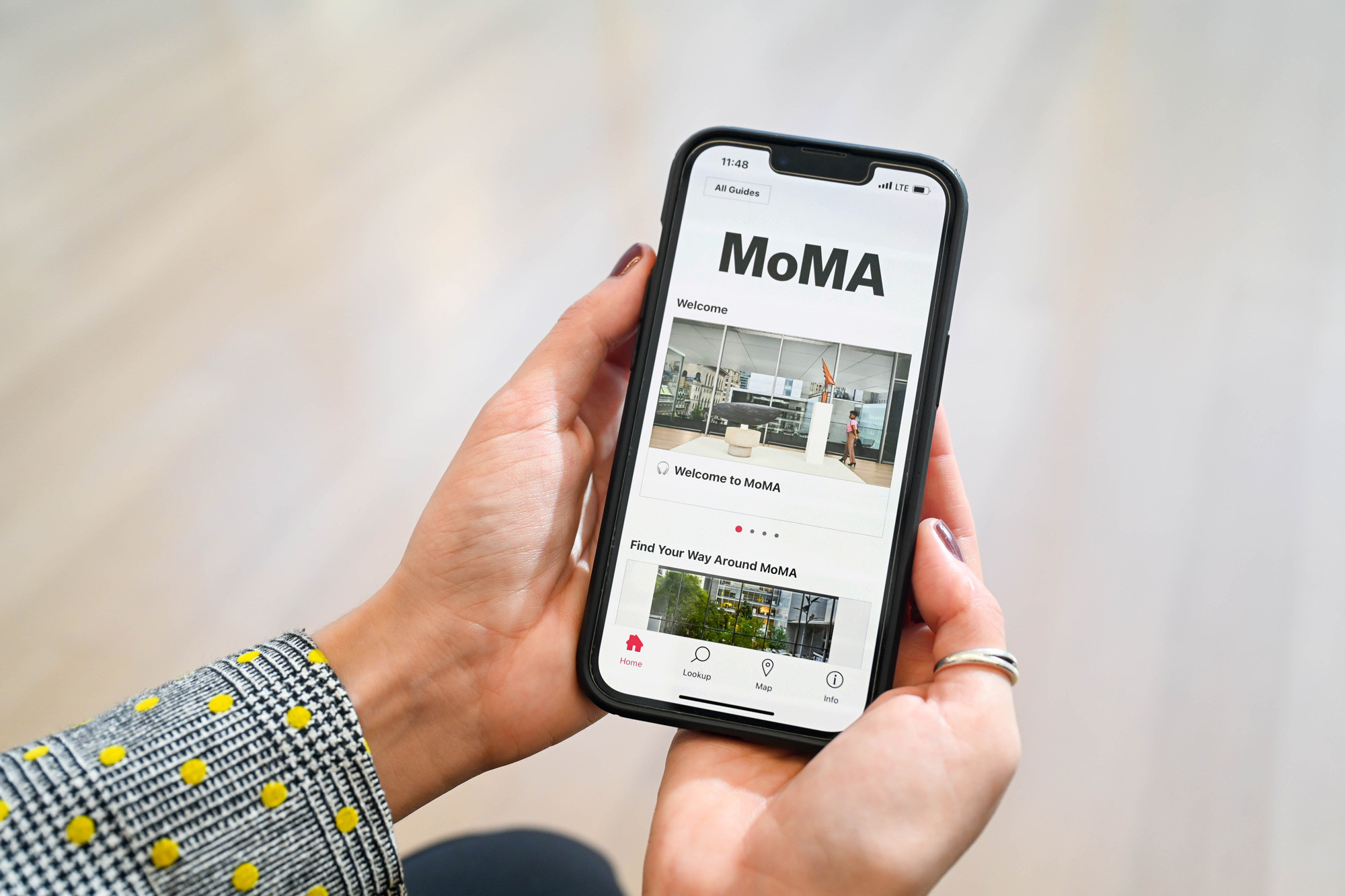 Two slightly cupped hands cradle a phone that displays the home page for MoMA’s guide on Bloomberg Connects. Photo: Edwina Hay