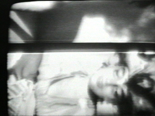 The image is a black and white photograph showing a blurred face with closed eyes, seemingly in a restful pose. Shadows and light effects create areas of high contrast across the image. This is an AI generated description. To give feedback, email ai@moma.org.