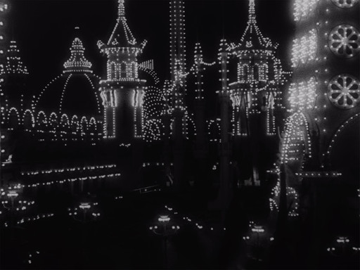 The image depicts a dark scene illuminated by numerous small, bright white lights outlining the shapes of domed and pointed structures. The lights create patterns and arches on tall buildings, with circular light designs visible on the right side. This is an AI generated description. To give feedback, email ai@moma.org.