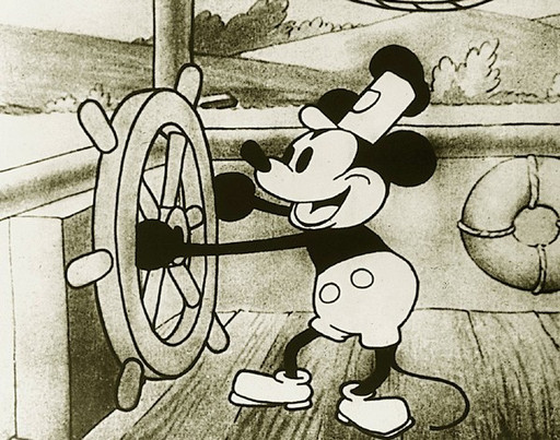 Black and white cartoon character with round ears and a cap is standing on a wooden deck, cheerfully turning a ship's wheel. The background includes trees, hills, and a life preserver. This is an AI generated description. To give feedback, email ai@moma.org.